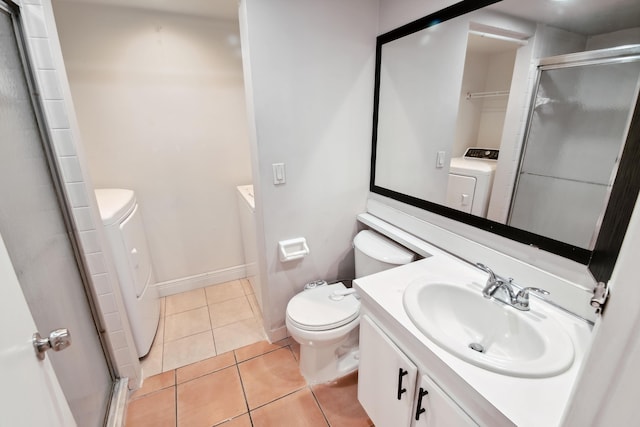 bathroom with a shower with door, toilet, vanity, and tile patterned flooring