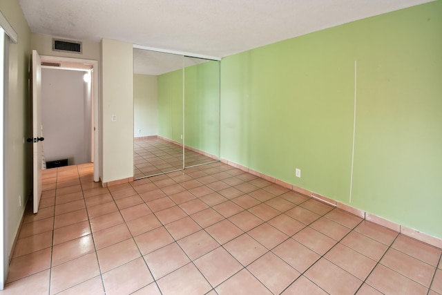 unfurnished bedroom with light tile patterned floors and a closet