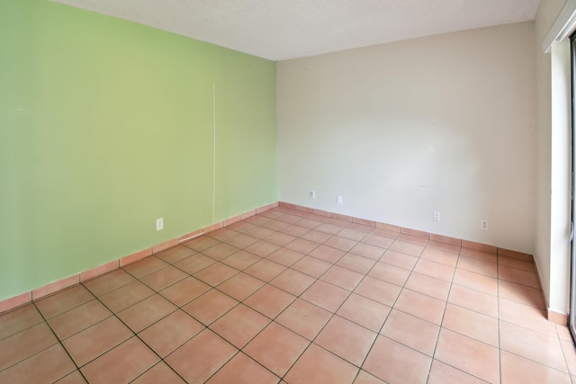 tiled spare room with a textured ceiling