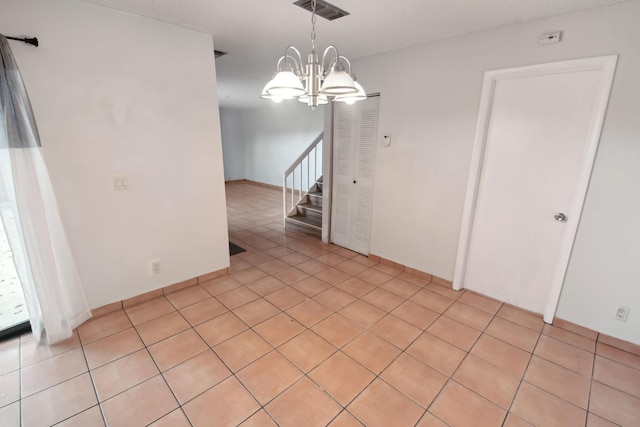 spare room featuring stairs, visible vents, an inviting chandelier, and light tile patterned flooring
