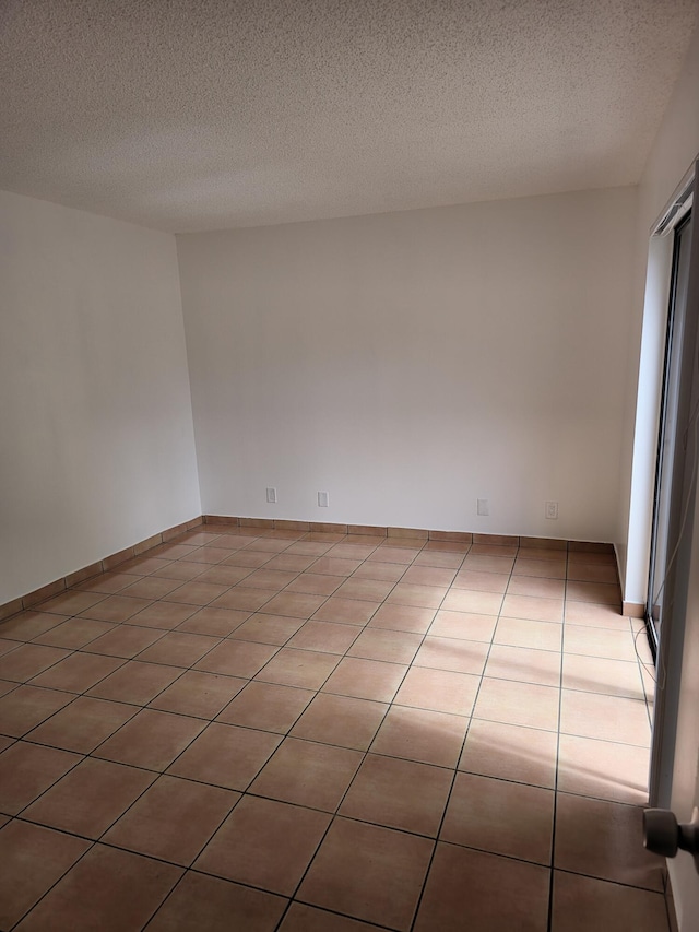 tiled spare room with a textured ceiling