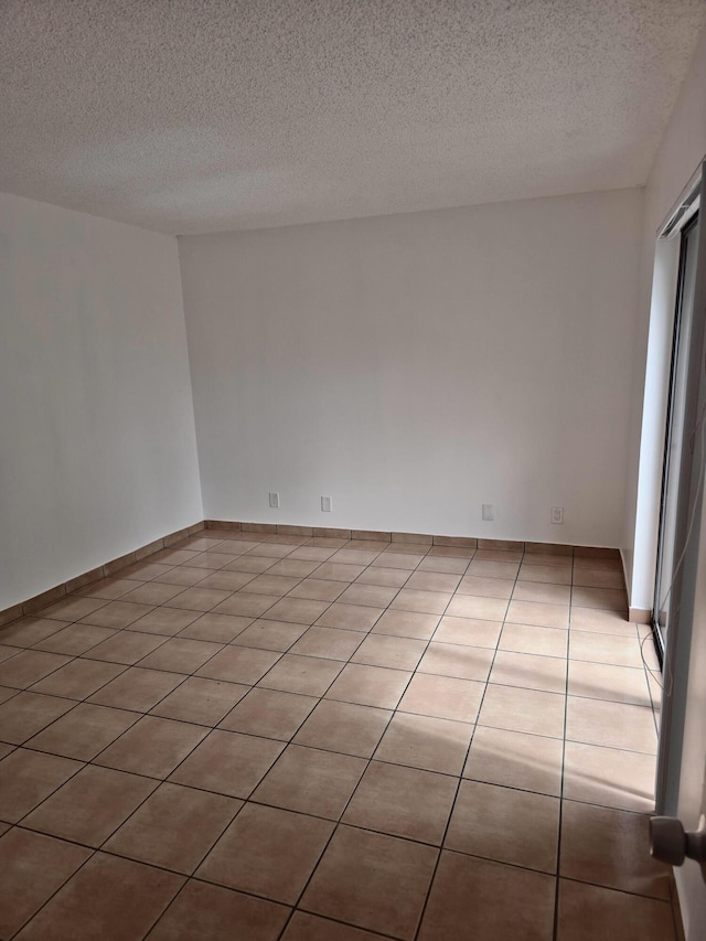 tiled spare room with a textured ceiling