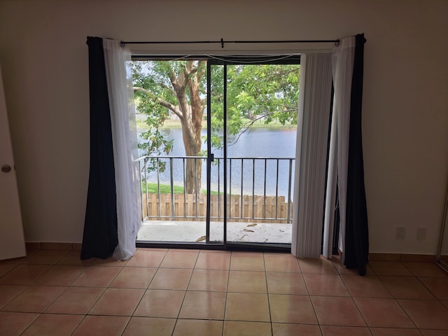 entryway with plenty of natural light, a water view, and light tile patterned floors