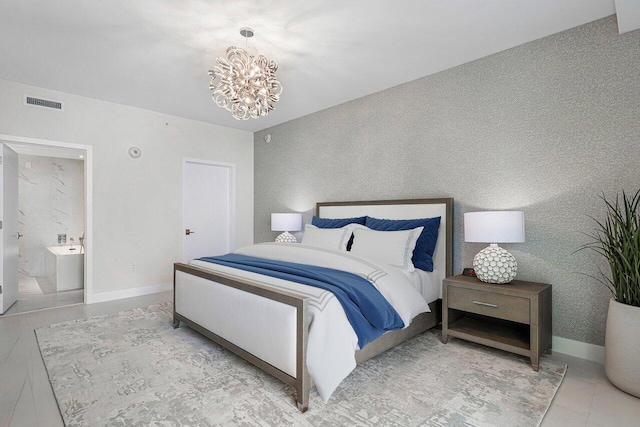 bedroom featuring a notable chandelier and connected bathroom