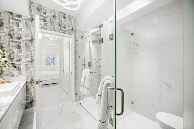 bathroom featuring vanity, toilet, tile walls, and a shower with door