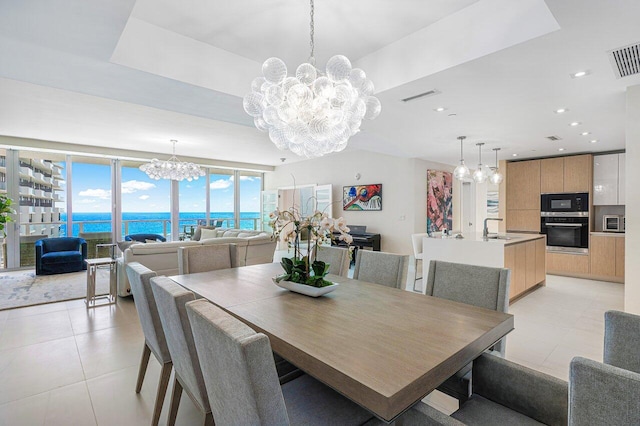 tiled dining space featuring sink and a water view