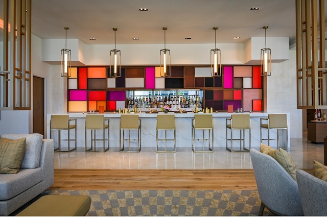 bar with pendant lighting and light wood-type flooring