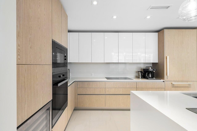 kitchen with light brown cabinets, white cabinetry, and black appliances