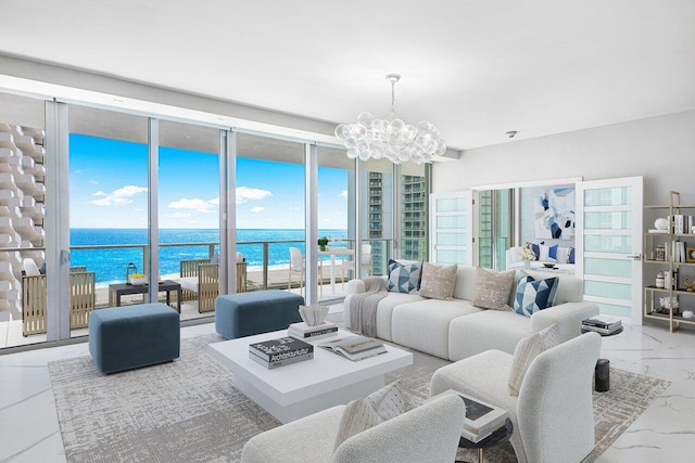 living room with a notable chandelier, a water view, and floor to ceiling windows