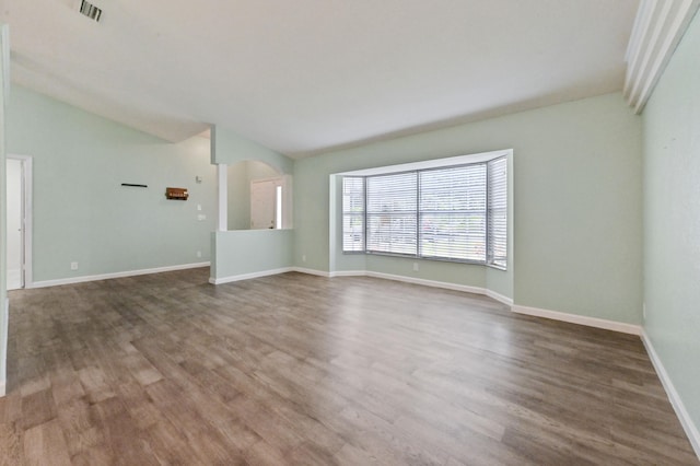 unfurnished living room with hardwood / wood-style floors and vaulted ceiling