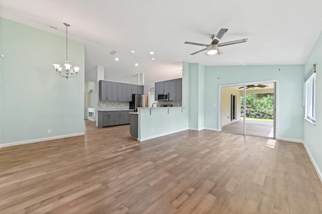 unfurnished living room with light hardwood / wood-style flooring, lofted ceiling, and ceiling fan with notable chandelier