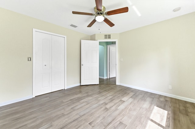 unfurnished bedroom with light hardwood / wood-style flooring, a closet, and ceiling fan