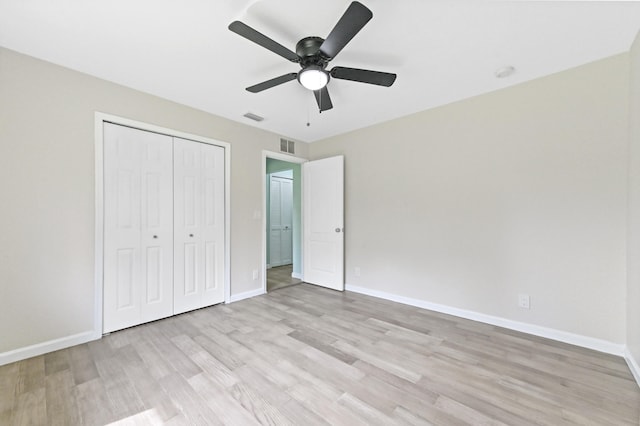 unfurnished bedroom with a closet, light wood-type flooring, and ceiling fan