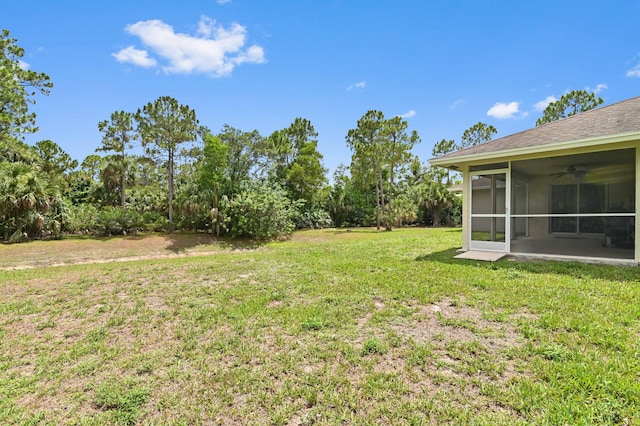 view of yard with a sunroom and ceiling fan