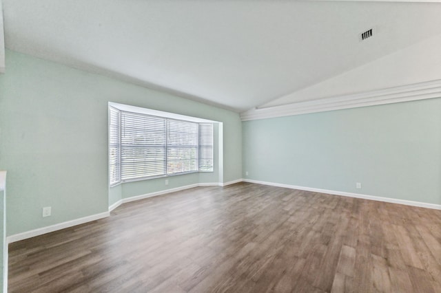 empty room featuring lofted ceiling and hardwood / wood-style floors