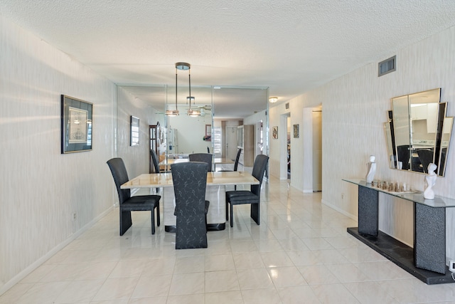 dining room featuring a textured ceiling and light tile patterned floors