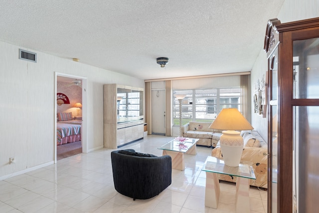 living room featuring light tile patterned flooring and a textured ceiling