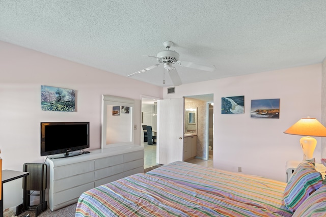 bedroom with ensuite bathroom, a textured ceiling, and ceiling fan