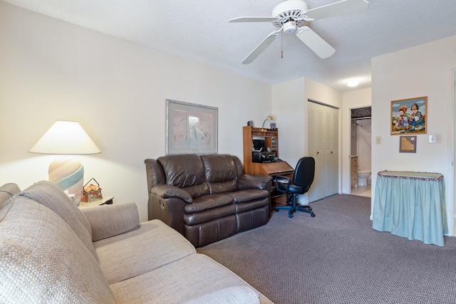 living room featuring a textured ceiling, carpet flooring, and ceiling fan