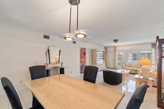 dining room featuring a textured ceiling and light tile patterned floors