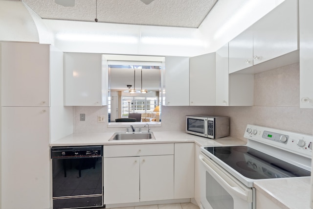 kitchen with black dishwasher, backsplash, white cabinetry, electric stove, and sink