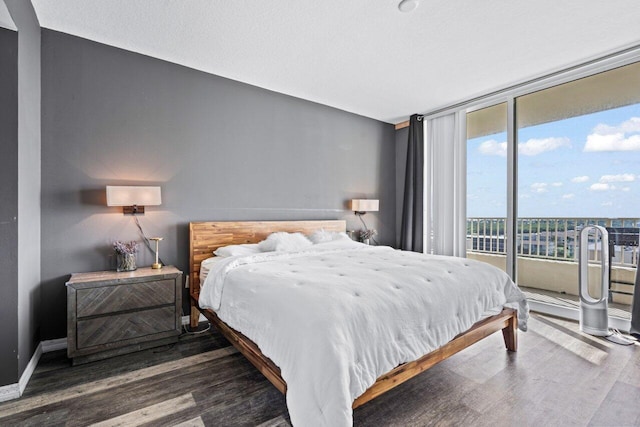 bedroom with access to exterior and dark hardwood / wood-style flooring