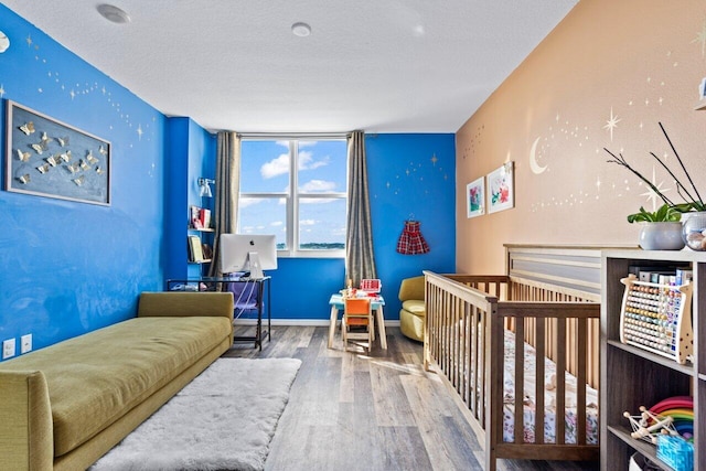 bedroom with wood-type flooring and a textured ceiling