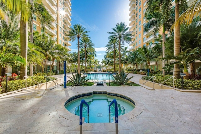 view of pool with a community hot tub and a patio