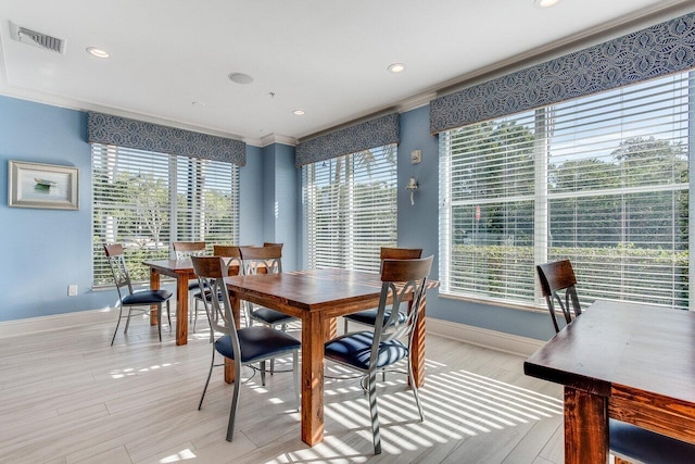 dining room featuring ornamental molding and light wood-type flooring