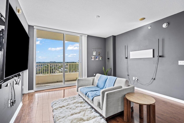 sitting room featuring a textured ceiling, floor to ceiling windows, and hardwood / wood-style floors