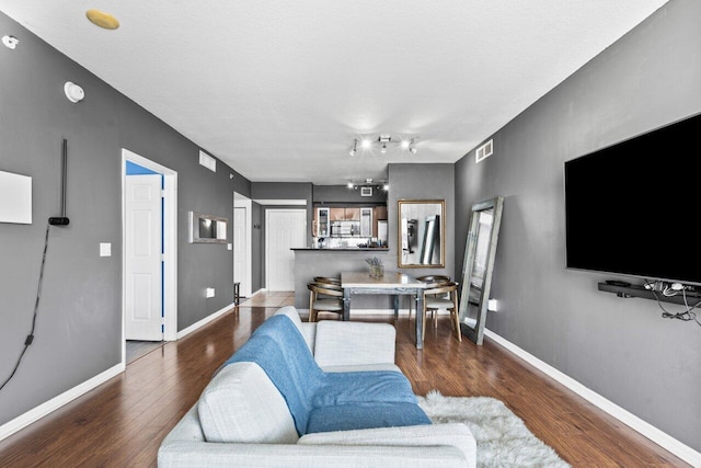 living room featuring dark wood-type flooring and a textured ceiling