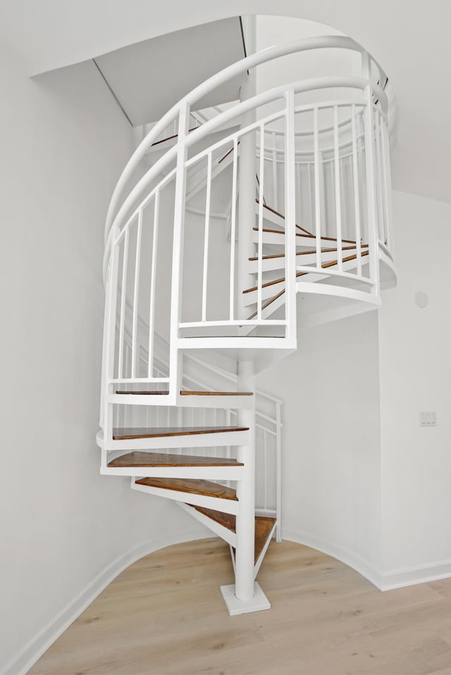 stairs featuring hardwood / wood-style floors