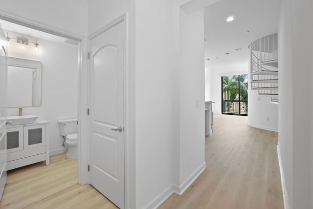 hallway featuring sink and light wood-type flooring