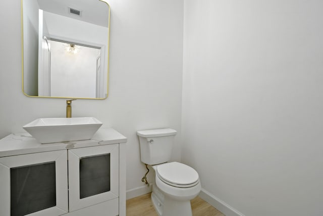 bathroom with vanity, wood-type flooring, and toilet