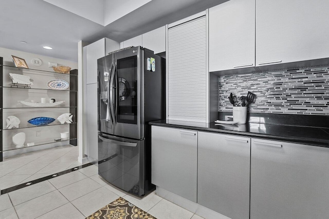 kitchen with backsplash, stainless steel refrigerator with ice dispenser, light tile patterned floors, and white cabinets