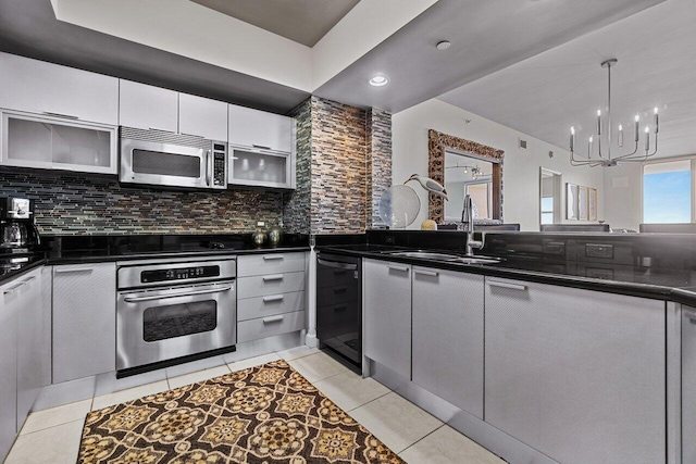 kitchen featuring black appliances, sink, a chandelier, and backsplash