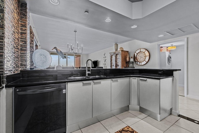 kitchen featuring light tile patterned flooring, sink, stacked washer / drying machine, stainless steel dishwasher, and a notable chandelier