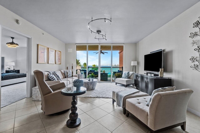 tiled living room with floor to ceiling windows and ceiling fan