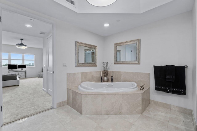 bathroom with tiled bath and tile patterned flooring