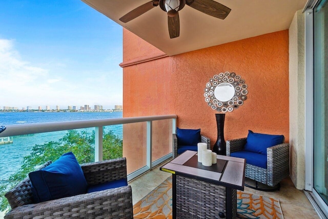 balcony with a water view and ceiling fan