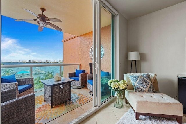 balcony featuring a water view and ceiling fan