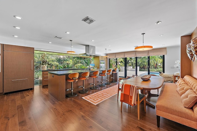 dining area featuring dark wood-type flooring and a wall of windows