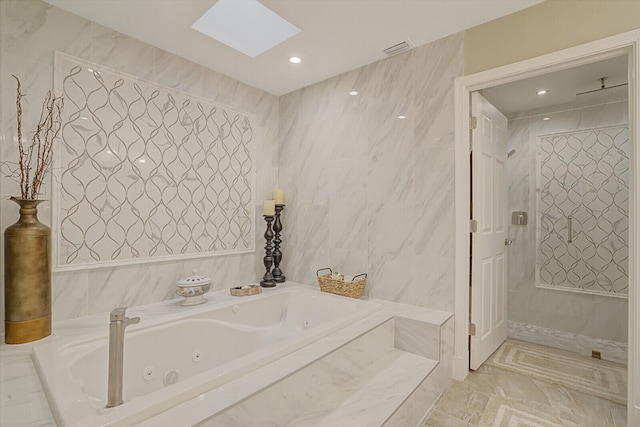 bathroom featuring tile walls, a skylight, and plus walk in shower