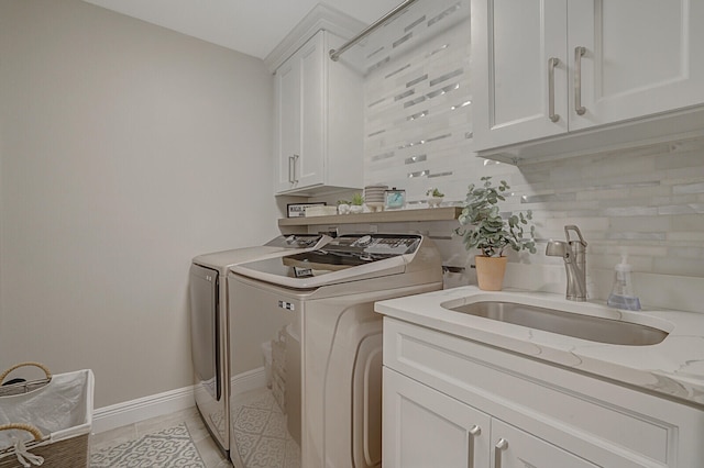 laundry area with cabinets, independent washer and dryer, sink, and light tile patterned floors