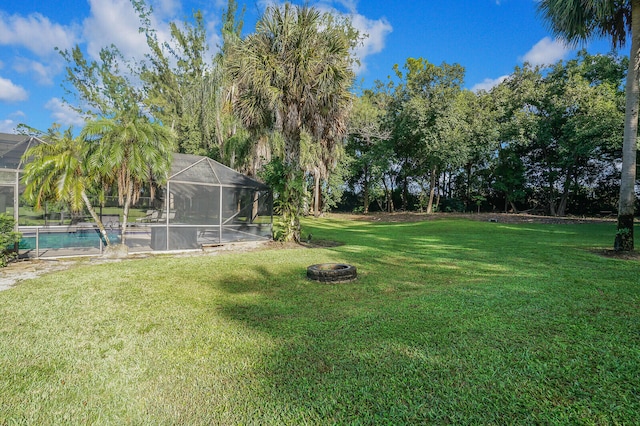 view of yard with a fire pit and glass enclosure