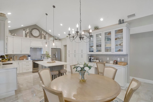 dining room with sink, high vaulted ceiling, and a chandelier