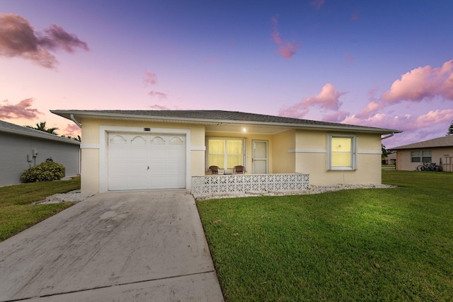 ranch-style house featuring a yard and a garage