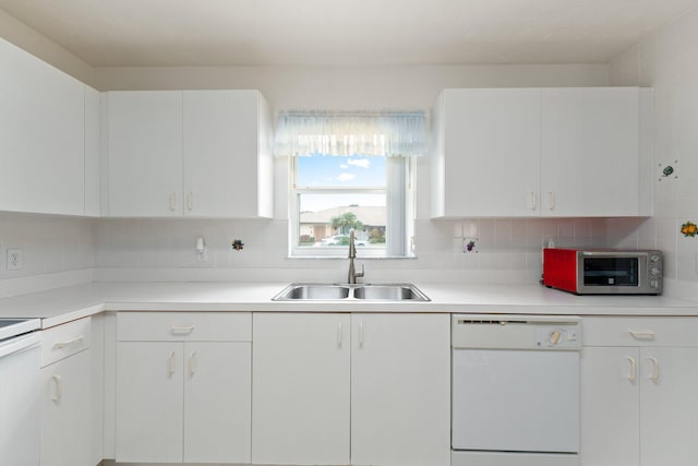 kitchen featuring white appliances, backsplash, white cabinetry, and sink