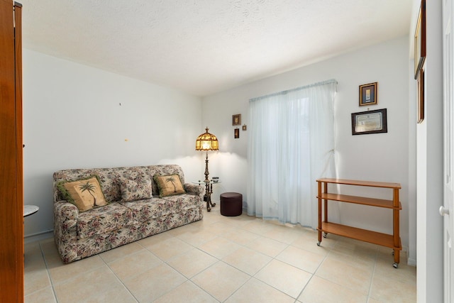 living room with a textured ceiling and light tile patterned floors