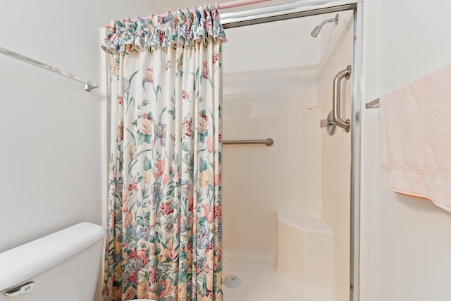 bathroom featuring curtained shower and toilet